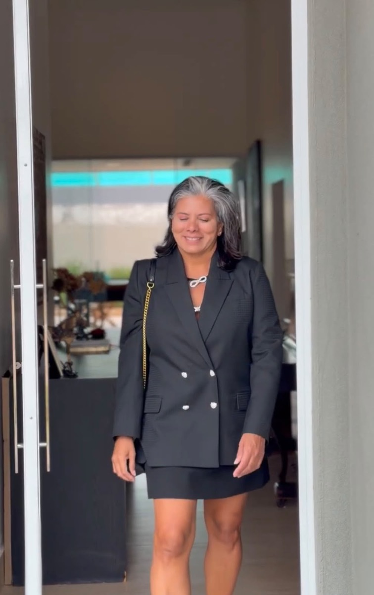 Doró com o mesmo vestido preto, blazer preto por cima e bolsa de corrente dourada